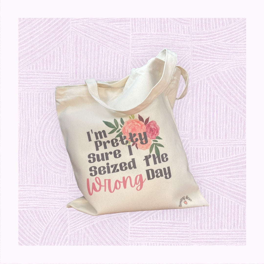 Canvas tote bag with the phrase ‘I’m pretty sure I seized the wrong day’ and floral arrangement