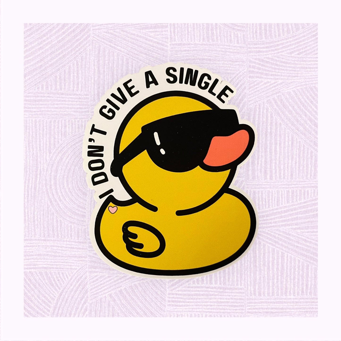 Die cut sticker of a rubber duck wearing sunglasses, with the phrase ‘I don’t give a single…’