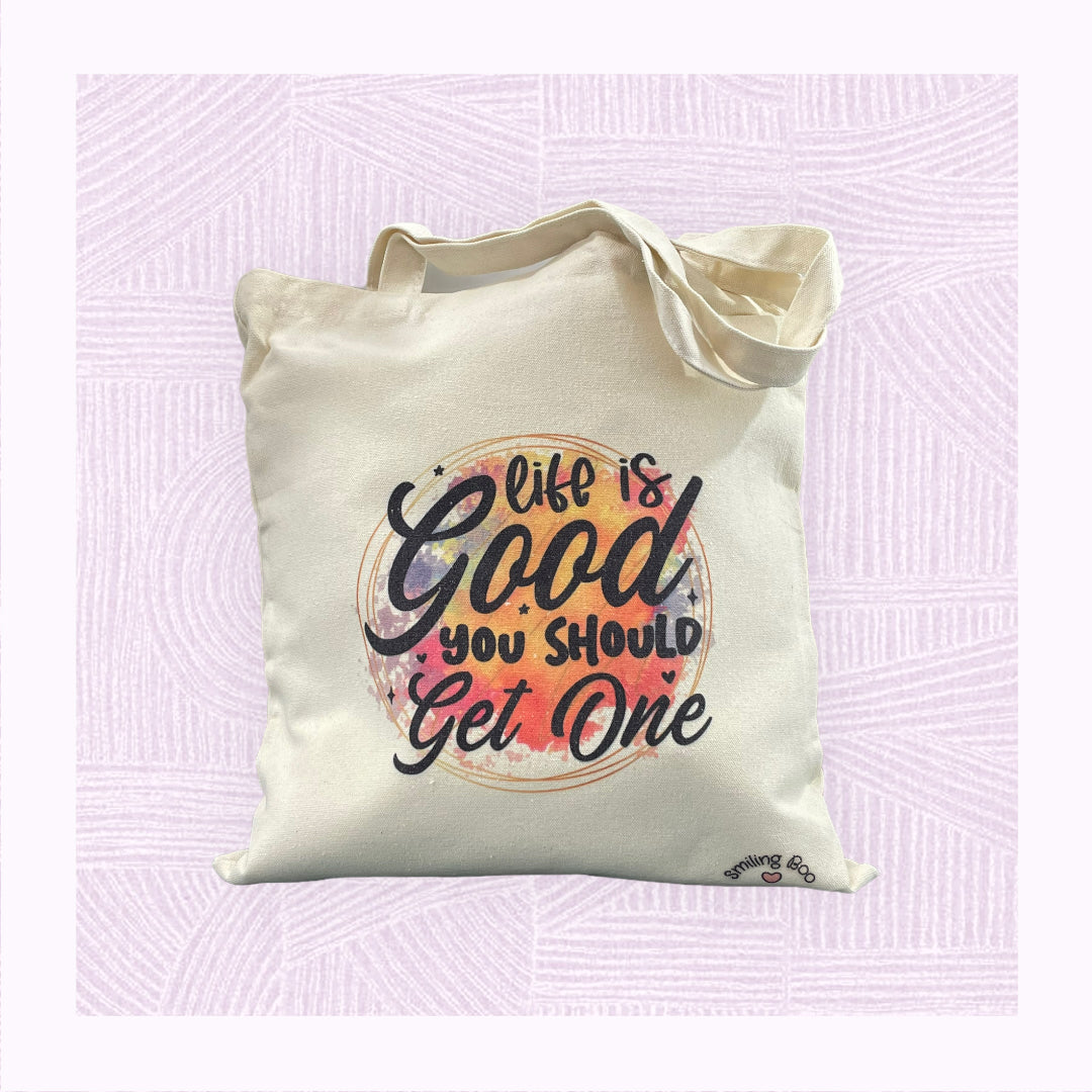 Canvas tote bag with a colourful watercolour patch with the phrase ‘Life is Good. You should get one’.