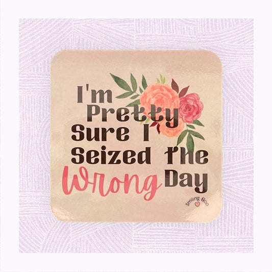 Square coaster with a pastel pink/peach watercolour background with the phrase ‘I’m pretty sure I seized the wrong day’ and floral arrangement