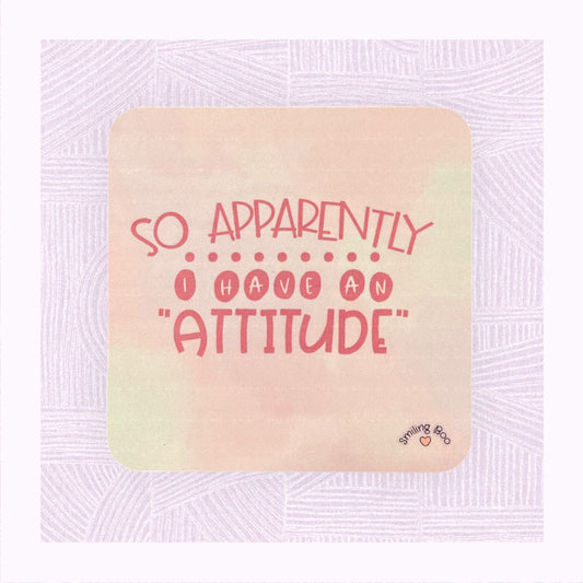 Square coaster with a pastel pink background and the phrase ‘Apparently I have an Attitude’ in bubble font.