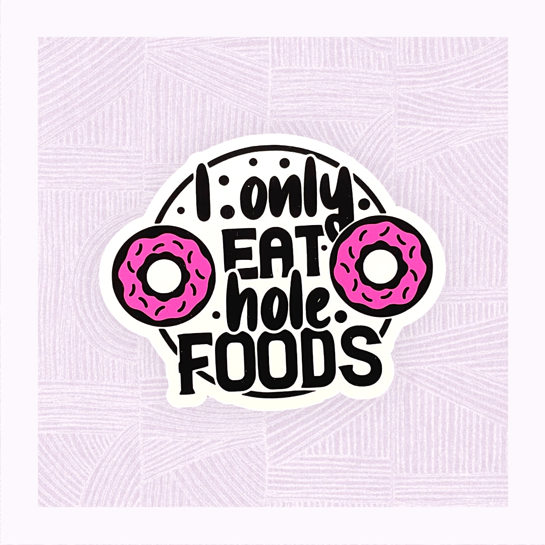 Die cut sticker with the phrase ‘I only eat hole foods’ with a pink doughnut either side.