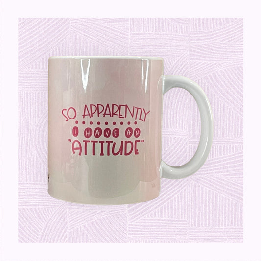 Ceramic mug with a pastel pink background and the phrase ‘Apparently I have an Attitude’ in bubble font.