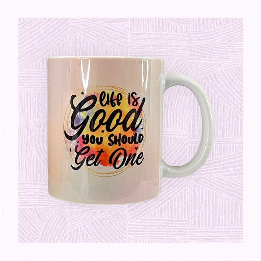 Ceramic mug with printed pastel background, and a colourful watercolour patch with the phrase ‘Life is Good. You should get one’.