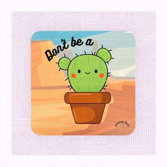 Square coaster with printed desert background, a cute cactus character with the phrase ‘Don’t be a…’ above it.