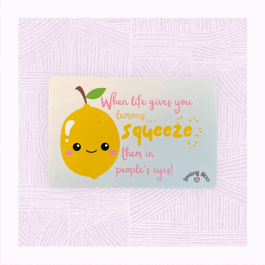 Postcard art print with a blue into yellow faded background, a cute lemon character in the foreground with the phrase ‘When life gives you lemons, squeeze them in people’s eyes’.