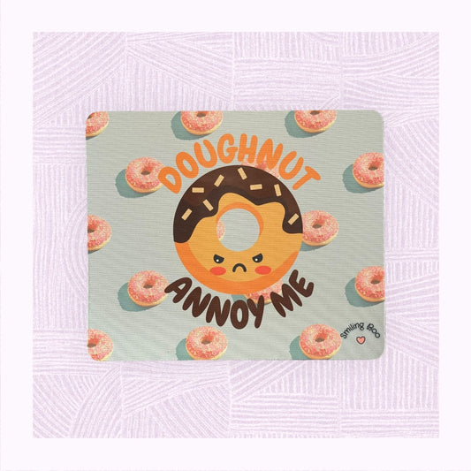Rectangle mouse mat with a blue background and pink doughnuts, and an angry looking doughnut character with the phrase ‘Doughnut Annoy Me’.