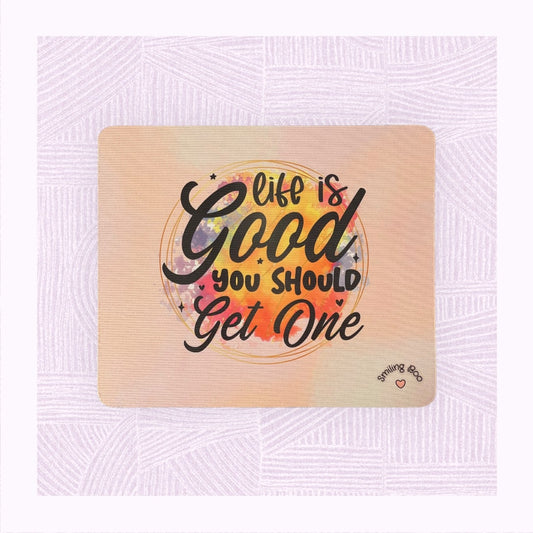 Rectangle mouse mat with printed pastel background, and a colourful watercolour patch with the phrase ‘Life is Good. You should get one’.