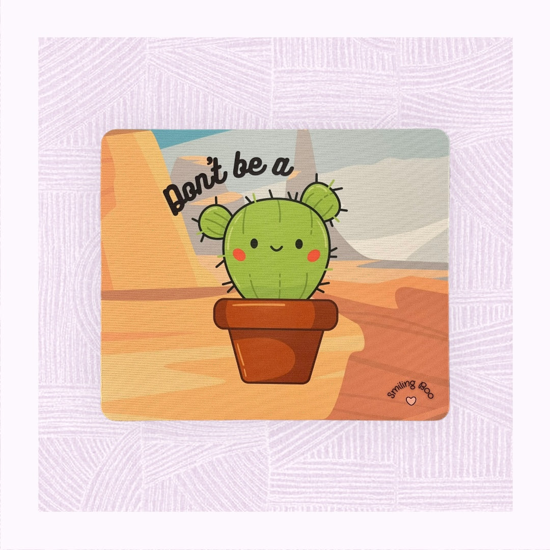Rectangle mouse mat with printed desert background, a cute cactus character with the phrase ‘Don’t be a…’ above it.