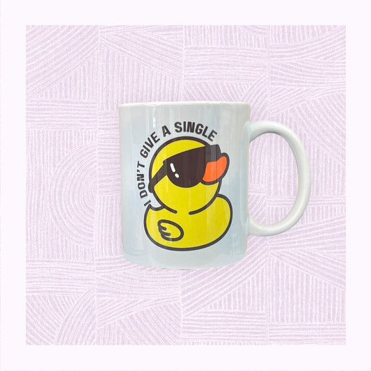 Ceramic mug with a blue and white watercolour background and a rubber duck wearing sunglasses, with the phrase ‘I don’t give a single…’